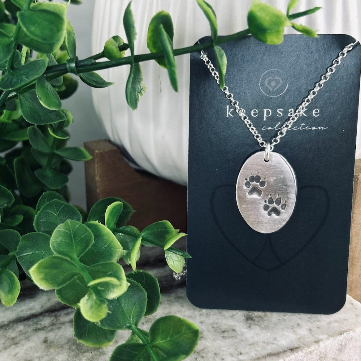 Fine silver oval shape pendant showcasing your pets pawprint. A sentimental keepsake, customizable with an optional chain or embellishment.
