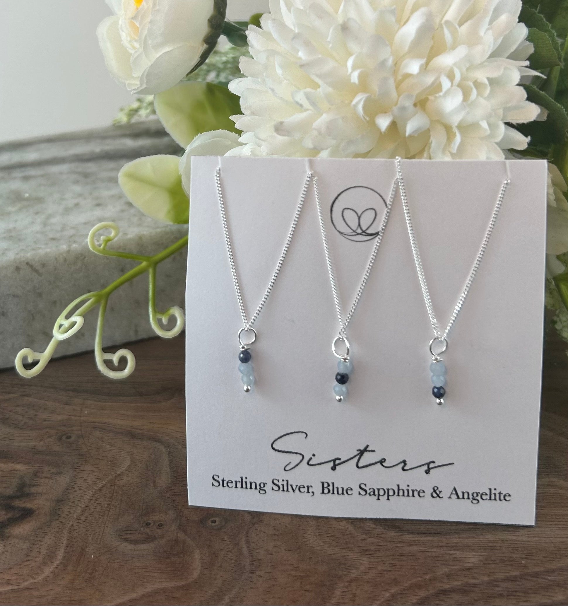 Sister necklace set with sapphire stones, uniquely placed to represent the older and younger sister—a timeless symbol of love and connection. Set includes 3 separate necklaces.