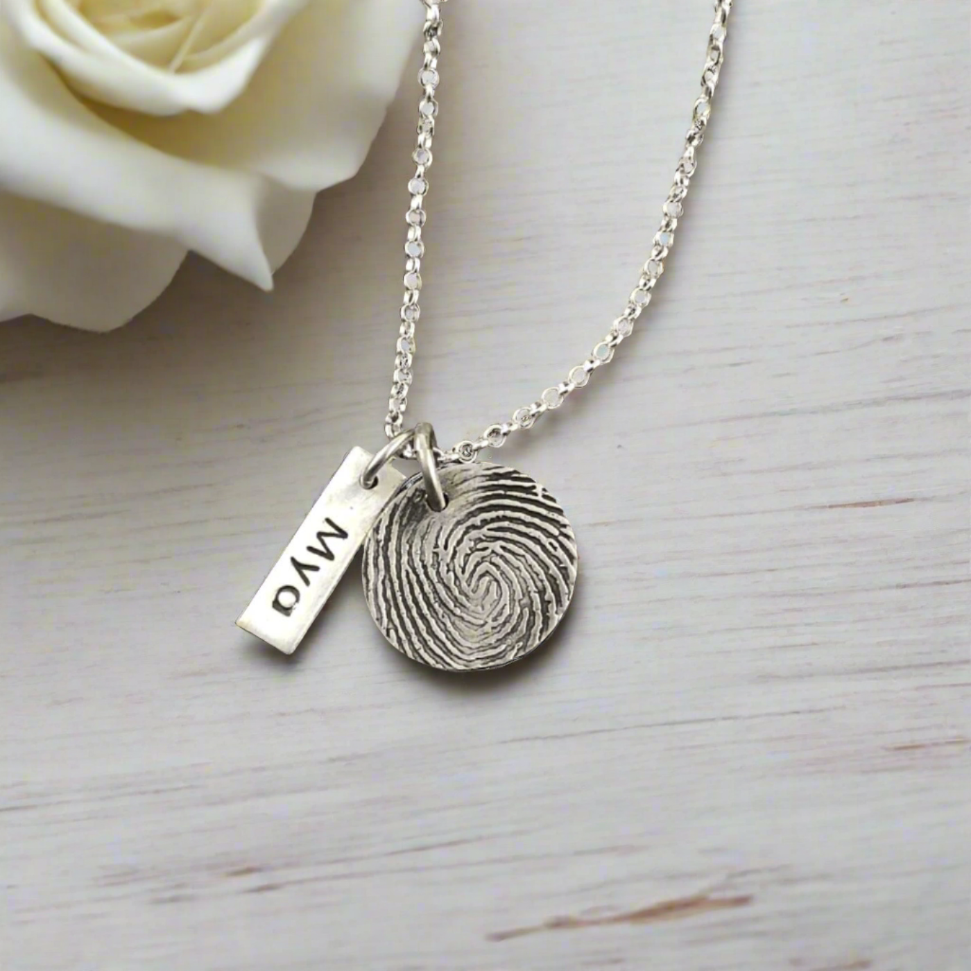 Fine silver circle fingerprint pendant, handcrafted from paper prints with enhanced detail. A meaningful keepsake with an optional chain or embellishment.