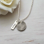 Fine silver circle fingerprint pendant, handcrafted from paper prints with enhanced detail. A meaningful keepsake with an optional chain or embellishment.