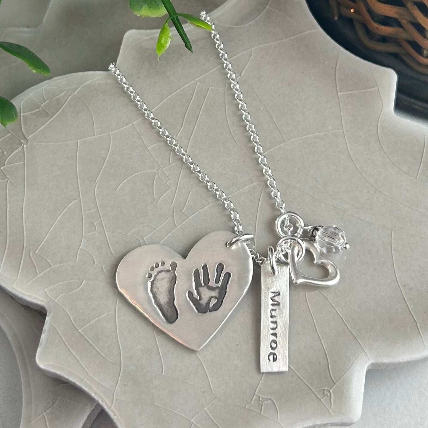 Fine silver pendant showcasing actual hand and/or footprints. Personalize with one or two prints and complete with an optional chain or embellishment.