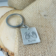 Fine silver square pendant showcasing actual hand and/or footprints. A meaningful keepsake, customizable with an optional chain or keyring.