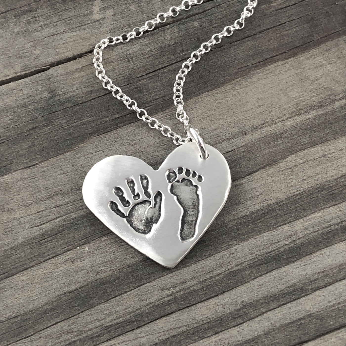 Fine silver pendant showcasing actual hand and/or footprints. Personalize with one or two prints and complete with an optional chain or embellishment.
