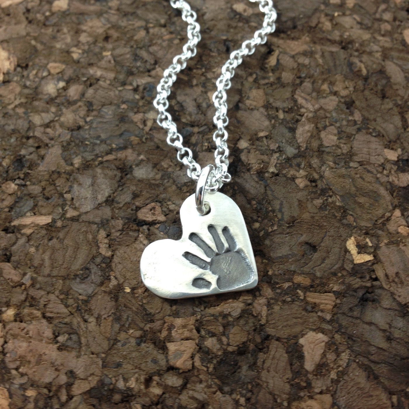 Small heart shaped pendant with your loved ones hand or footprint.