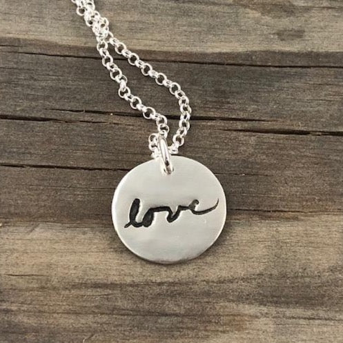 Small handcrafted fine silver circle pendant featuring a replica of a loved one's handwriting, creating a meaningful and personalized keepsake.