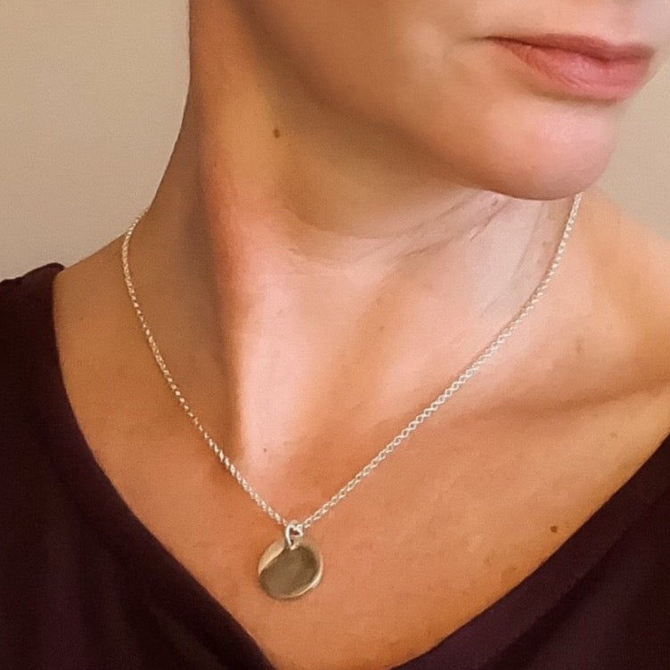Small circle fine silver fingerprint pendant, handcrafted to preserve the exact shape and indentation of a loved one’s finger for a unique and sentimental keepsake.