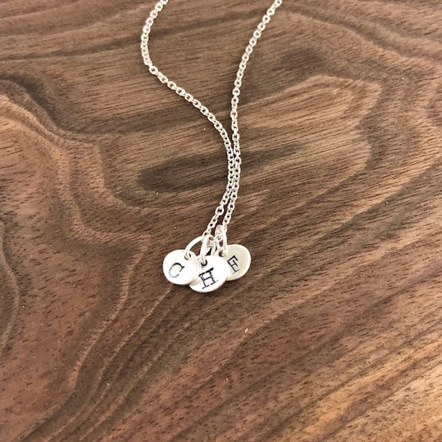 Tiny sterling silver initial necklace with hand-stamped 6x7mm charms. Simple and elegant, available with a 16" or 18" chain and optional extra charms.