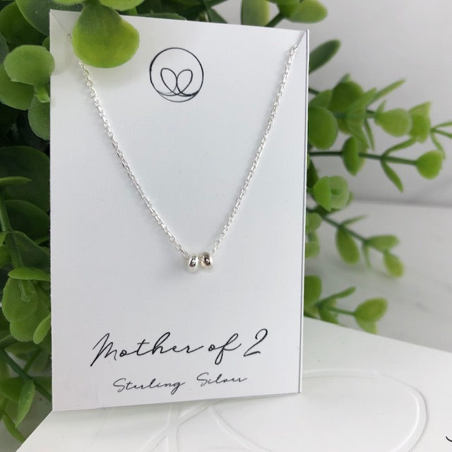 Sterling silver mother necklace with two beads, symbolizing love and connection. Handmade with care for a meaningful and sentimental keepsake.