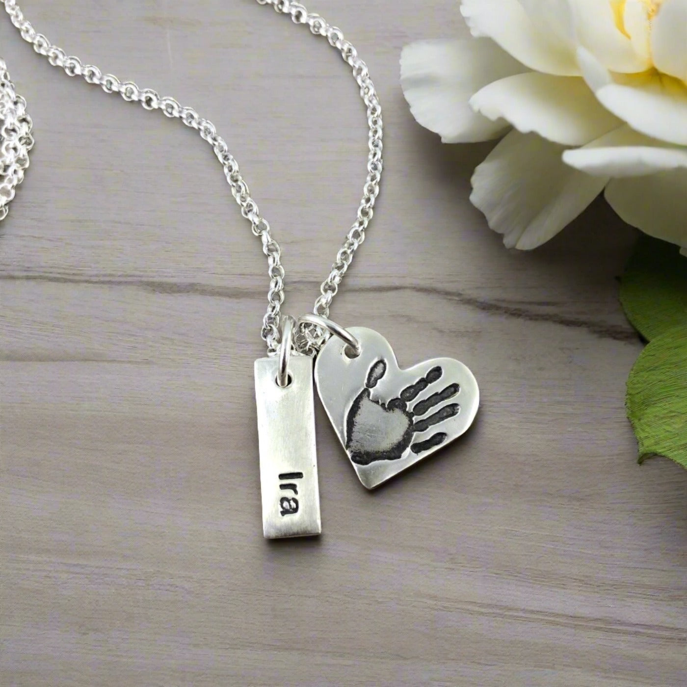 Small heart shaped pendant with your loved ones hand or footprint.