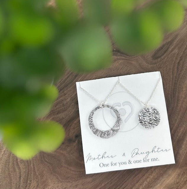 Handcrafted 99.9% fine silver mother-daughter necklace set with a necklace for each of you.  One necklace with a larger circle, the other necklace has a smaller circle.