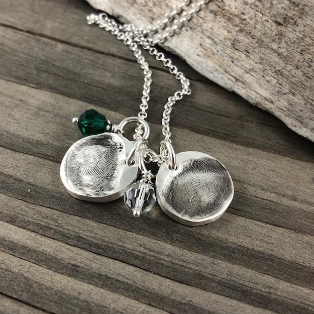 Small circle fine silver fingerprint pendant, handcrafted to preserve the exact shape and indentation of a loved one’s finger for a unique and sentimental keepsake.