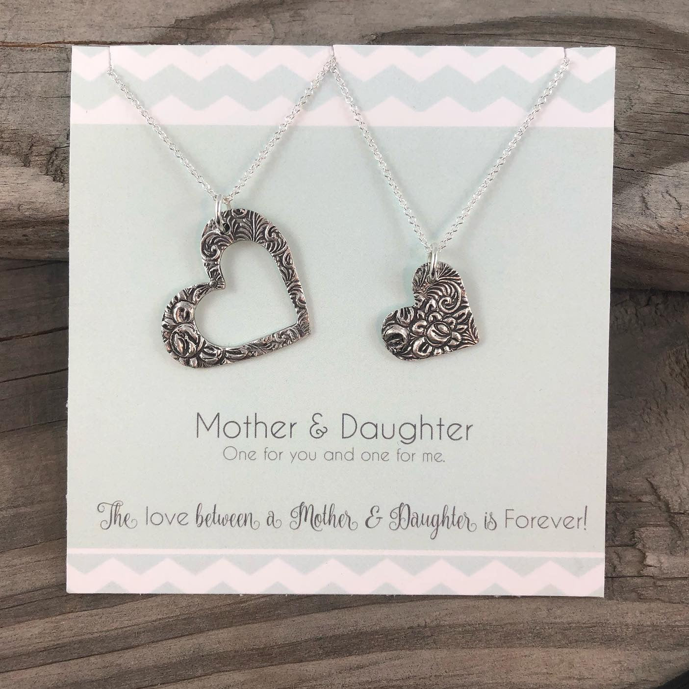 Handcrafted 99.9% fine silver mother-daughter necklace set with a necklace for each of you.  One necklace with a larger heart, the other necklace has a smaller heart.