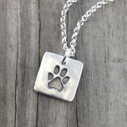 Fine silver square shape paw print pendant, handcrafted to showcase your pet’s actual print. A simple, meaningful keepsake with optional chain or embellishment.