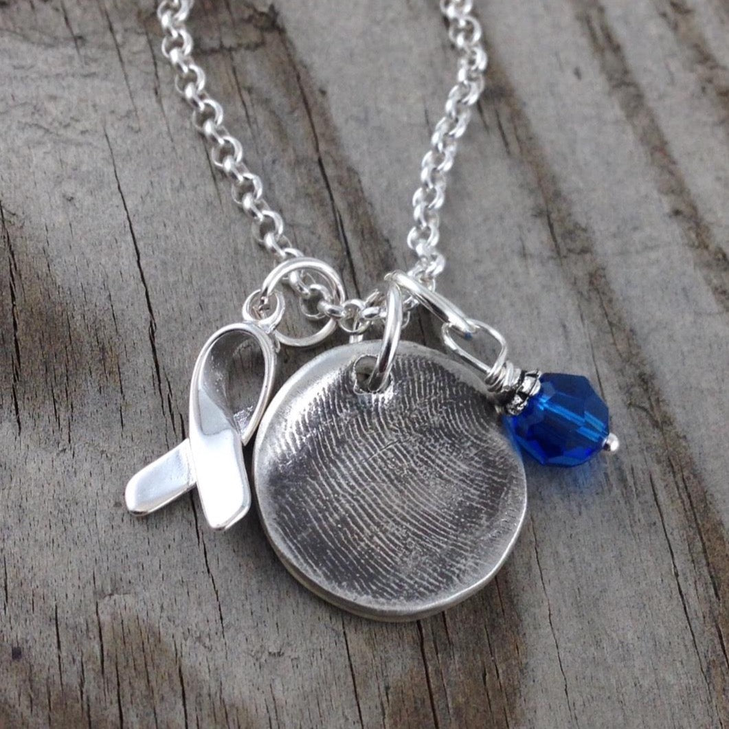 Small circle fine silver fingerprint pendant, handcrafted to preserve the exact shape and indentation of a loved one’s finger for a unique and sentimental keepsake.