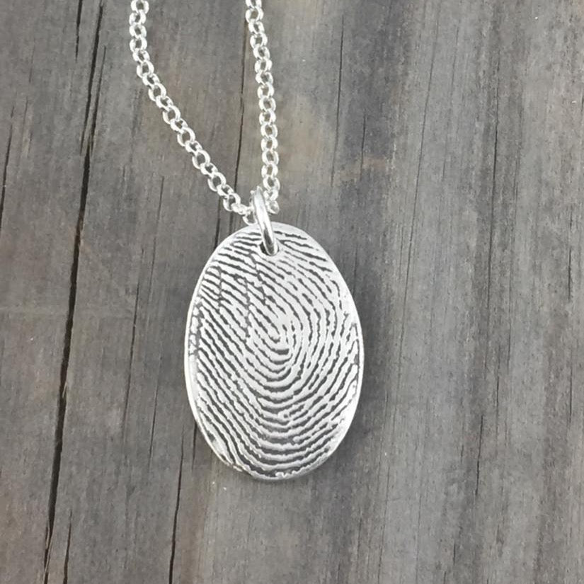 Fine silver fingerprint pendant, handcrafted from paper prints for a detailed and meaningful keepsake. Optional chain or embellishment available