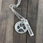 Small handcrafted fine silver circle pendant featuring a pet’s actual paw print, a meaningful keepsake to honor and cherish your furry friend.