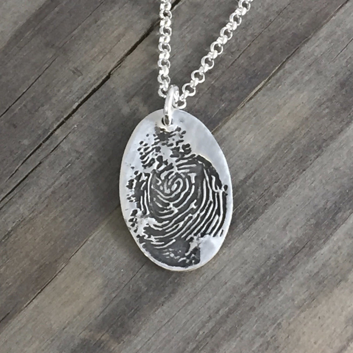 Fine silver fingerprint pendant, handcrafted from paper prints for a detailed and meaningful keepsake. Optional chain or embellishment available