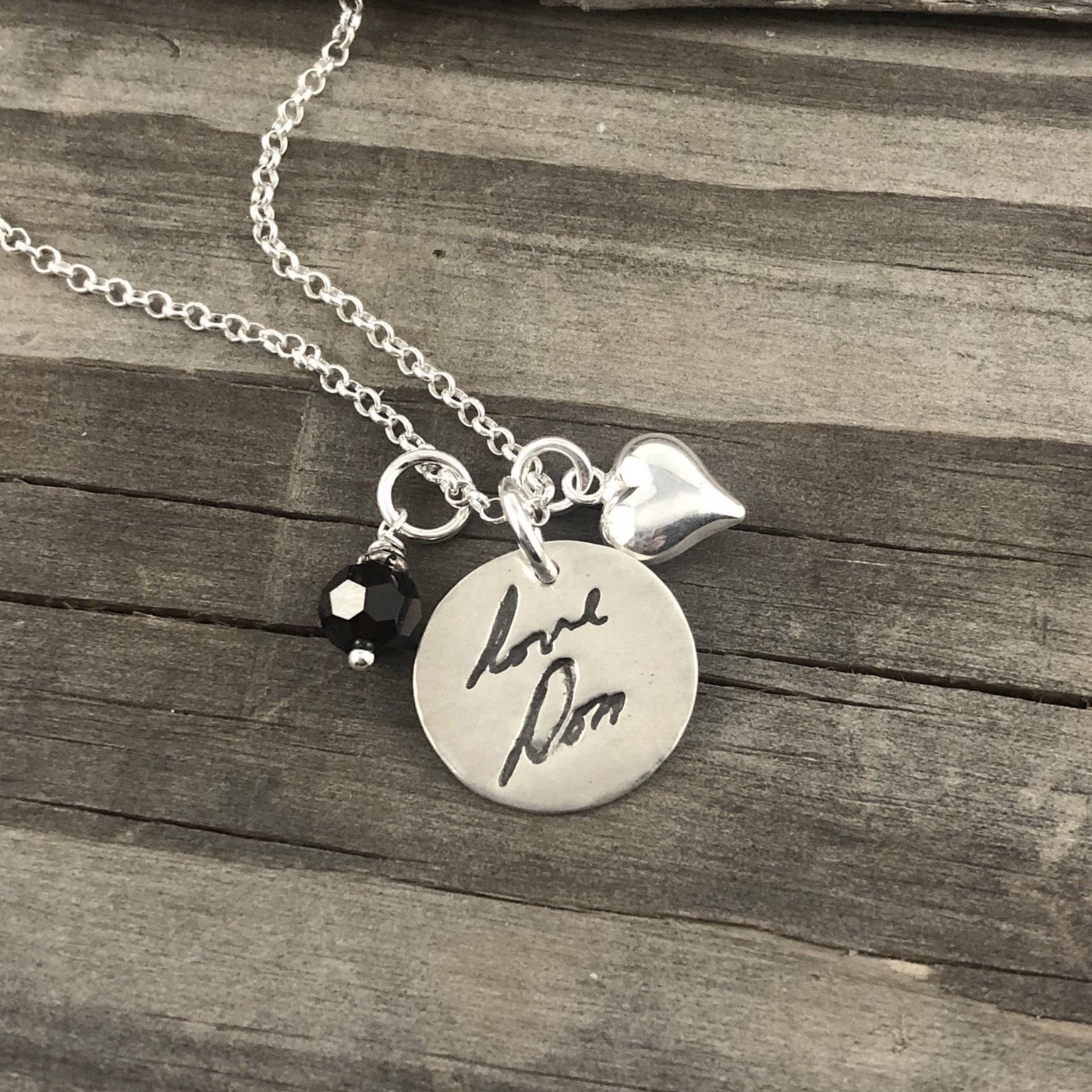 Small handcrafted fine silver circle pendant featuring a replica of a loved one's handwriting, creating a meaningful and personalized keepsake.