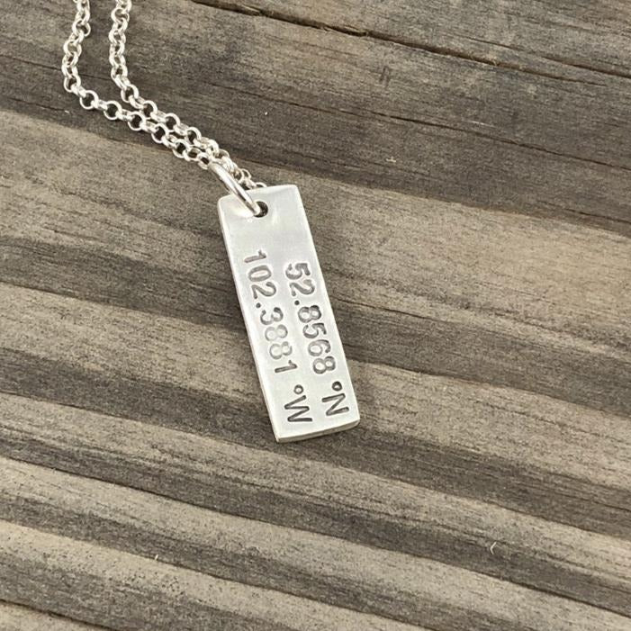 Graduation necklace featuring custom coordinates, symbolizing home or a first school. A meaningful keepsake for students starting a new journey.