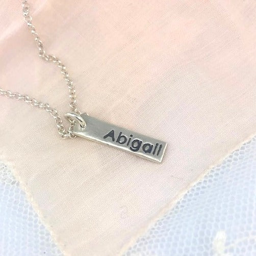 Personalized fine silver name tag necklace with up to 3 custom tags. Comes with an 18” rolo chain, with the option to upgrade for a longer length.
